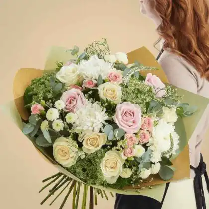 A large bouquet of white and light pink roses, chrysanthemums, and eucalyptus.
