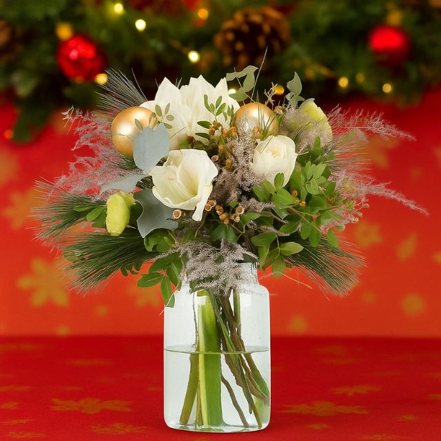 Blog 5 A festive Christmas flower vase arrangement with white blooms, pine needles, dried grass, and gold ornaments in a clear jar vase. Christmas Vase Flowers for sale
