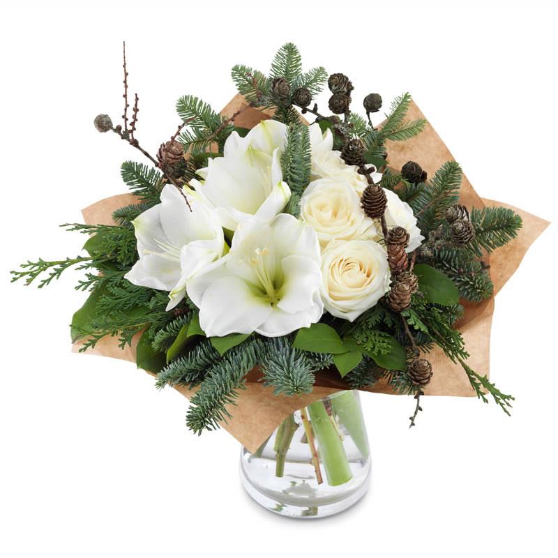 Blog 4 A beautiful, unique Christmas flower arrangements featuring white amaryllis and roses with pine branches and cones, wrapped in brown paper and set in a vase. Buy Amaryllis Flowers For Christmas