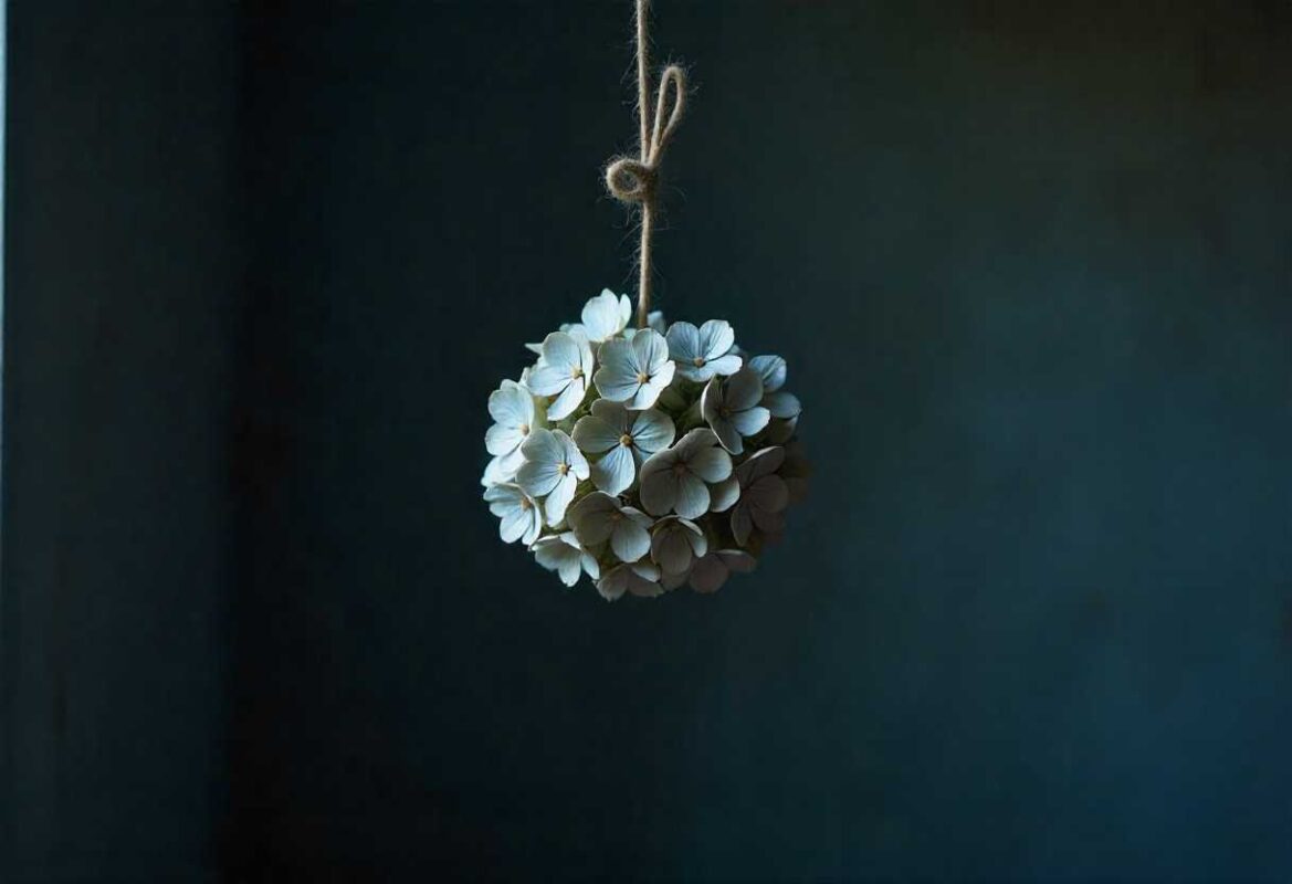 How to Dry Hydrangea Flowers: A Simple Step-by-Step Guide 1 A creative hanging decoration made from small, light-colored dried Hydrangea florets tied with rustic twine, showcasing another method of How to Dry Hydrangea Flowers.